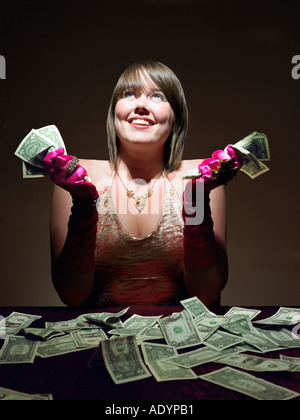 Junge Frau mit Geld mit Blick der Freude Stockfoto