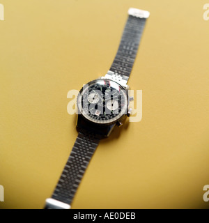 BREITLING SCHWEIZER CHRONOGRAPH ARMBANDUHR MIT SELEKTIVEN FOKUS AUF GELBEM HINTERGRUND Stockfoto