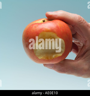 HERR MANN HAND HÄLT EINEN APFEL GEBISSEN PINK LADY Stockfoto