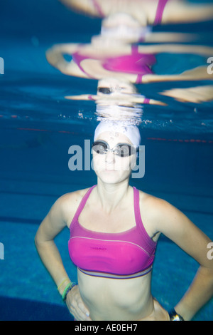 Wasser Sport Woman in lila Schwimmen Anzug Übung unter Wasser in einem blauen Swimmingpool Stockfoto