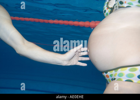Schwangere paar Schwimmen im Pool Paartherapie Stockfoto