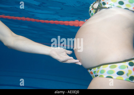 Schwangere paar Schwimmen im Pool Paartherapie Stockfoto
