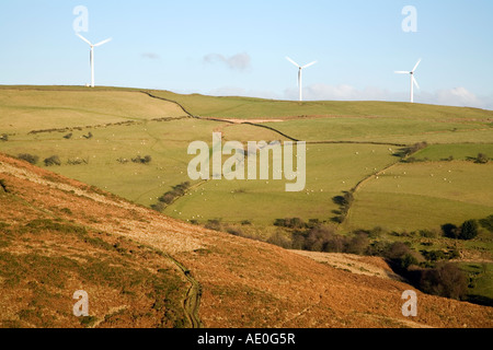 Ländliche Hanglage mit einer Reihe von Windturbinen in Bewegung Und weidende Schafe gegen einen blauen Himmel mit einigen Wolken Stockfoto