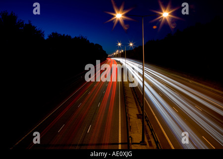 Streifen von Autoscheinwerfer auf Autobahn in der Nacht. Schöne glatte Kurve. Stockfoto