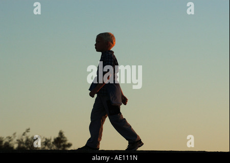 Silhouette eines walking jungen am Abend Stockfoto