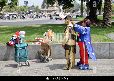 eine Frau verkleidet als Minnie Maus hilft einen Mann in seinem Indianer Kostüm in Barcelona, Spanien Stockfoto