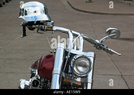 Eine hochglanzpolierte Helm am Lenker einer geparkten Harley-Davidson Stockfoto