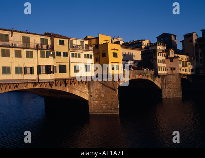 Italien, Toskana, Florenz. Westseite des Ponte Vecchio Brücke in warmen, goldenen Licht mit Menschen stehen auf Mittelteil. Stockfoto