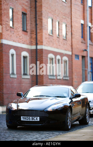 Grand Tourer schwarz Aston Martin DB9 in städtische Straße mit roten Ziegelsteinen geparkt und gepflasterten Gassen in wohlhabenden Leeds Stockfoto