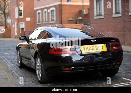 Grand Tourer schwarz Aston Martin DB9 in städtische Straße mit roten Ziegelsteinen geparkt und gepflasterten Gassen in wohlhabenden Leeds Stockfoto