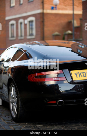 Grand Tourer schwarz Aston Martin DB9 in städtische Straße mit roten Ziegelsteinen geparkt und gepflasterten Gassen in wohlhabenden Leeds Stockfoto