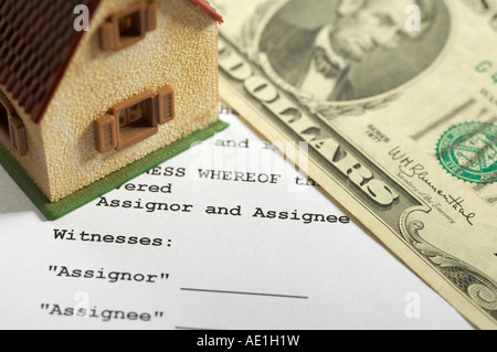 Miniatur-Haus und Dollar-Banknote auf einen Vertrag Stockfoto