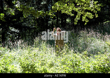 Junger Mann Position-Messung mit GPS-Empfänger in der Mitte des Waldes im Nationalpark Nizke Tatry, Slowakei Stockfoto