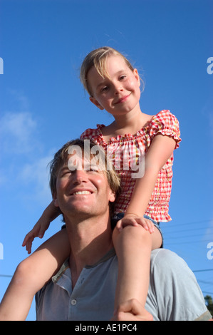 Kleines Mädchen saß auf ihrem Daddy s Schultern Stockfoto