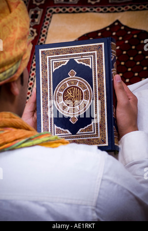 Mann, der Koran hält Stockfoto