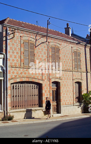 Senior Woman with Botengang Bags, alten, gemauerten Haus Sacy, Champagne, Frankreich Stockfoto