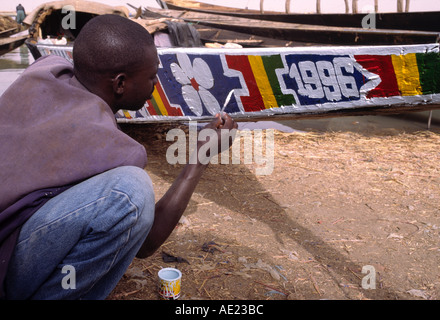 Mann, die Malerei seiner Piroge an den Ufern des Flusses Niger, Mopti, Mali Stockfoto