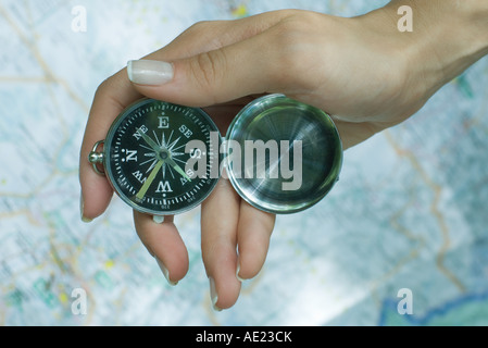 Frau Hand mit Kompass, Karte im Hintergrund Stockfoto