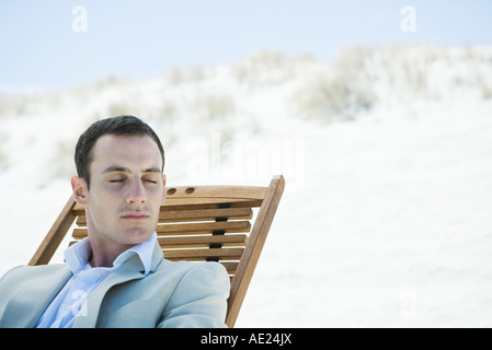 Geschäftsmann, sitzen im Liegestuhl am Strand, Augen geschlossen Stockfoto