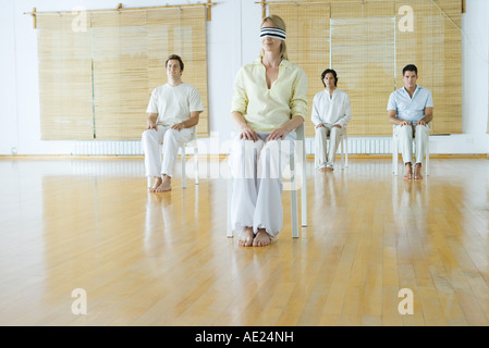 Gruppentherapie, Frau im Vordergrund, die mit verbundenen Augen Stockfoto