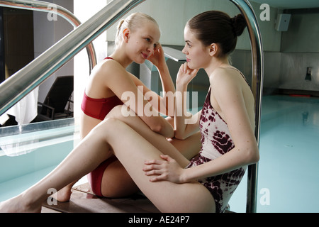 Zwei junge Frau sitzt neben Spa-pool Stockfoto