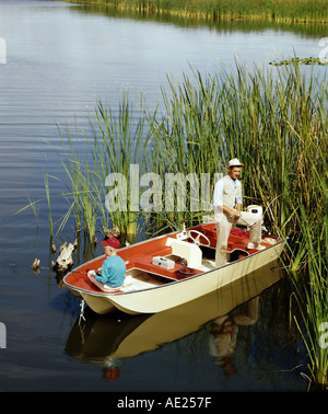 Vater Sohn von kleines Motorboot im See angeln Stockfoto