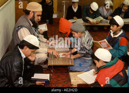 Ein Imam lehrt muslimischen jungen den Koran an einer Schule in einer Moschee in Bradford, West Yorkshire, England Stockfoto