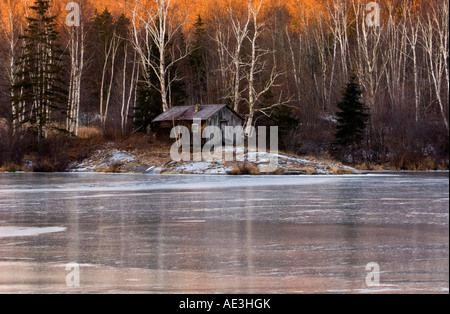 Morgen-Reflexionen in frischem Eis St. Pothier See, mit Sauna bauen, Greater Sudbury, Ontario, Kanada Stockfoto
