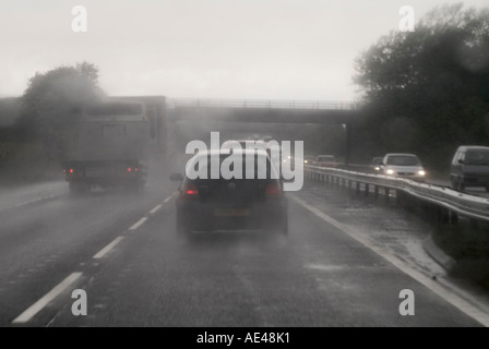 Fahren mit schlechter Sicht im Regen auf einer zweispurigen Straße in England. Stockfoto