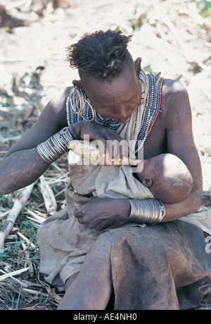 Ein Pokot Großmutter füttern Kühe Milch ihr Enkelkind mit einem Kürbis in der Nähe von Sigor nördlichen Kenia in Ostafrika Stockfoto