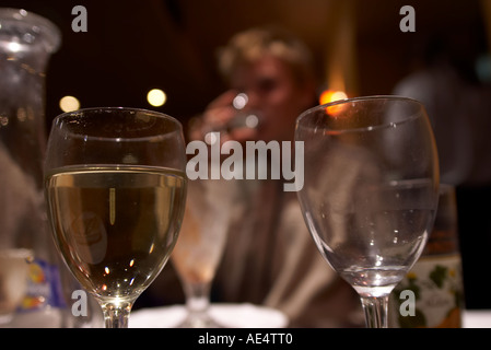 zwei Gläser Wein ein gefülltes leer in einem Dunkelrestaurant Stockfoto