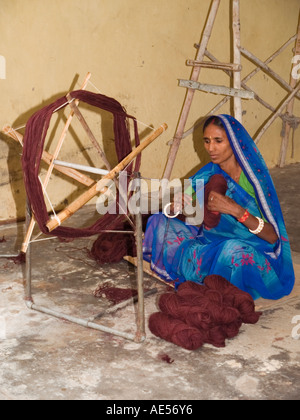 Demonstration der Spinnen von Wolle mit asiatische Dame in Tracht saß auf Boden Stockfoto