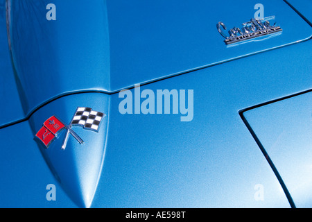 Fronthaube eines blauen 1965 Chevrolet Corvette Sting Ray Oldtimers mit Typenschild und gekreuzten Flaggen Wappen Stockfoto