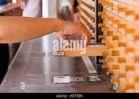 Hand greift in eine hölzerne Schublade herausziehen Omikuji Vermögen am Sensoji buddhistischen Tempel in Tokio Japan Stockfoto