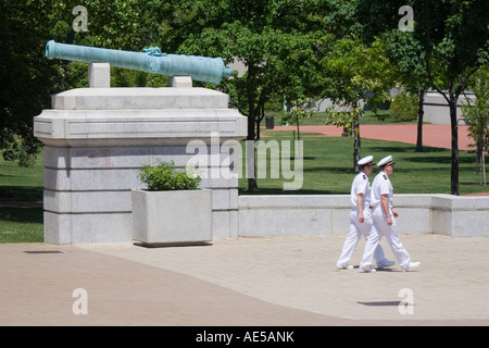 Zwei männliche Matrosen in weißen Service Uniformen vorbeigehen Kanone auf dem Campus der United States Naval Academy Annapolis Maryland Stockfoto