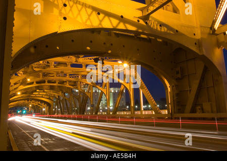 Lichter von Autos Reisen über die gold Stahlkonstruktion der Tower Bridge bei Nacht in Sacramento, Kalifornien Stockfoto