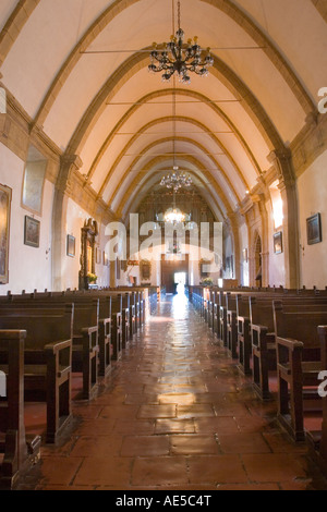 Kirchenschiff der Carmel Mission Basilika von Vorderseite der Kirche mit Reihen von Bänken und Mittelgang zum vorderen Eingang Stockfoto