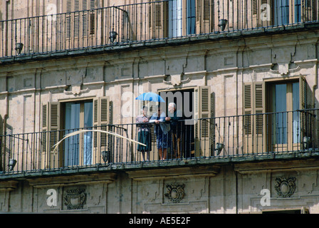 Gruppe von älteren Menschen stehen auf Balkon mit Sonnenschirm Salamanca Spanien Stockfoto