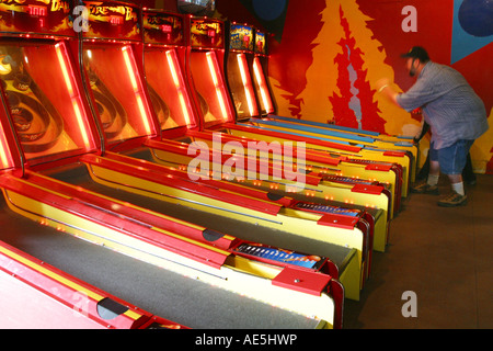 Stämmige Mann Arcade-Spiel mit Ball und Reifen auf Santa Cruz Boardwalk Amusement Park Santa Cruz, Kalifornien Stockfoto