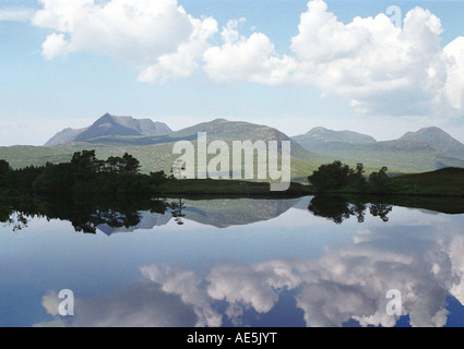 Berge und geschwollenen Wolken reflektiert in einem klaren, blauen See im Hochland von Schottland Stockfoto