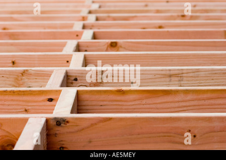 Bauvorhaben Gebäude Holz blockiert in einem gestaffelten Muster zwischen Fußbodenbalken in ein Wohn- Stockfoto