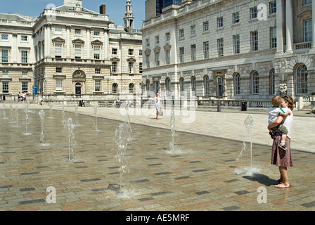 Mutter mit Kind und stand neben den Brunnen im Innenhof des Somerset House Strand London England Stockfoto