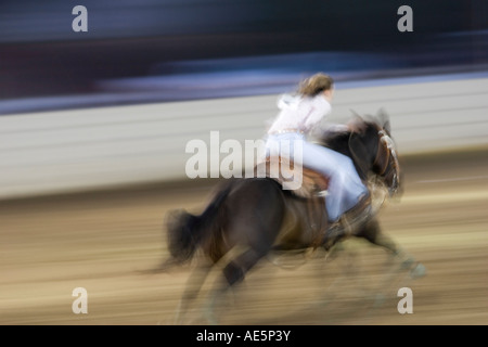 Teenager-Mädchen Rennen auf ihrem Pferd in einer Unschärfe, wie sie in einer Rennveranstaltung Lauf antreten Stockfoto