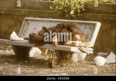 Obdachloser schläft auf Parkbank Stockfoto