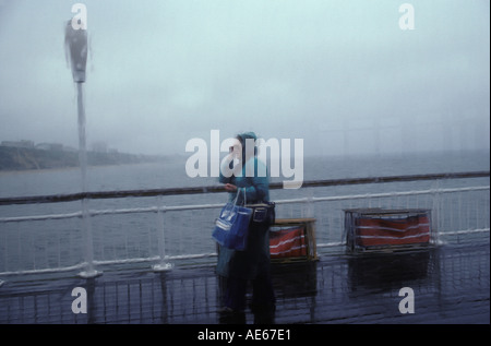 Brighton Palace Pier ein einsamer Tourist im strömenden Regen Brighton, East Sussex, England um die 1985 1980er Jahre Großbritannien HOMER SYKES Stockfoto