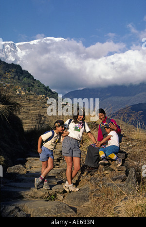 Christine Kolisch und Bodhi Garrett begrüßen eine Sherpani & ihres Sohnes in der Nähe von Siklis mit Lamjung Himal hinter NEPAL HIMALAYA Stockfoto