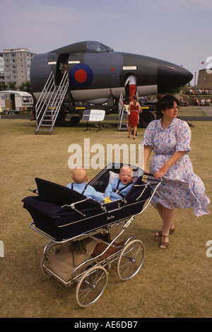 Twin Silver Cross Doppelwagen 1980er Jahre UK. Mutter und Zwillinge bei einer RAF-Demonstration Bournmouth Dorset, Südküste Englands um 1985 HOMER SYKES Stockfoto