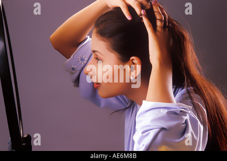 RHS70984 South Asian Indian Girl coiffure Haar mit Hände vor einem Spiegel Modell Release Nummer 442 Stockfoto