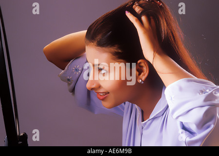 RHS70985 South Asian Indian Girl coiffure Haar mit Hände vor einem Spiegel Modell Release Nummer 442 Stockfoto