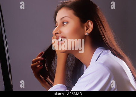 RHS70986 South Asian Indian Girl coiffure Haar mit Hände vor einem Spiegel Modell Release Nummer 442 Stockfoto